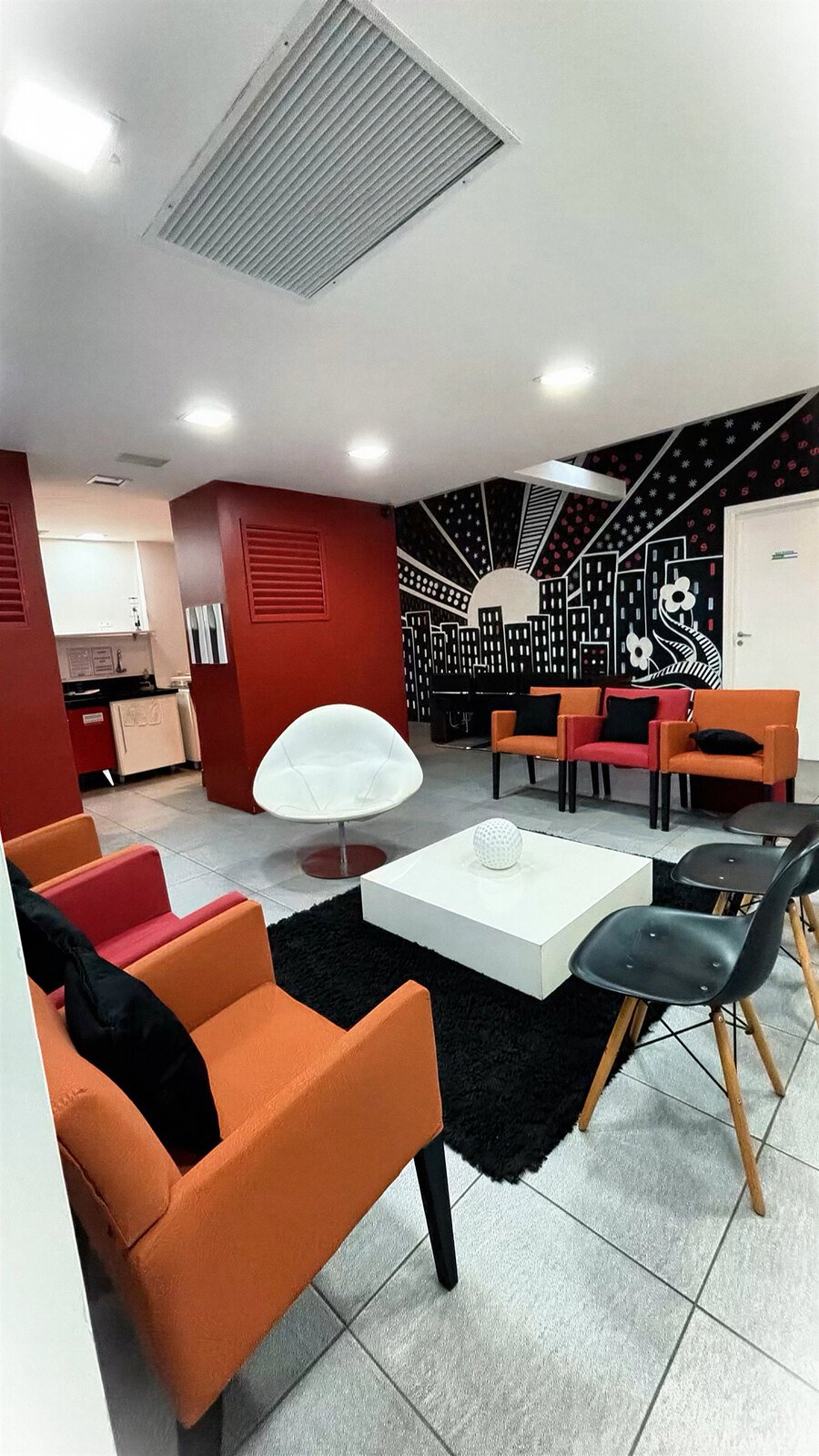 Recepção do escritório com poltronas e mural ilustrado