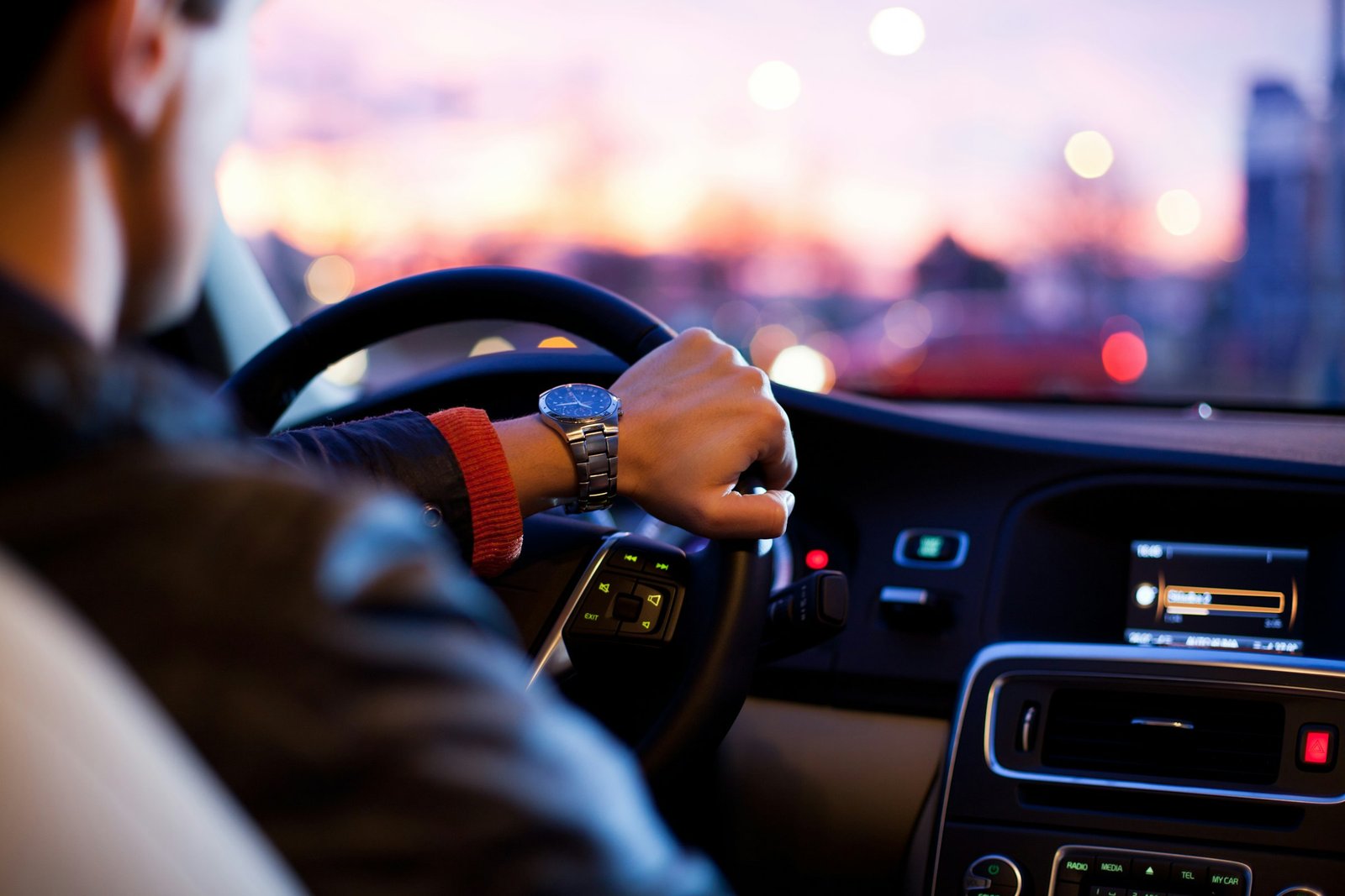 Motorista ao volante do veículo financiado ao entardecer